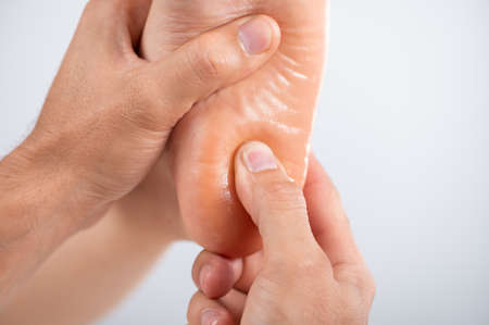 The specialist does a relaxing or restorative massage on the heel close upの写真素材