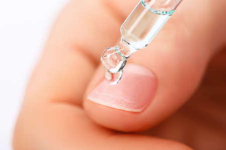 pipette with a drop of nail care or treatment products close-up.の写真素材
