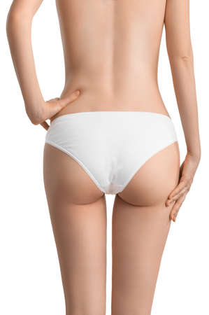 A slender girl in classic white underwear shows off her waist and toned buttocks. The concept of diet, exercise, body care or getting rid of celluliteの写真素材