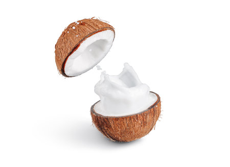 Coconut milk splash from split coconut on white isolated background, freeze motionの写真素材