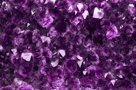 The texture of a mineral precious or semiprecious amethyst stone, shimmering with purple shades, is close-up.の写真素材