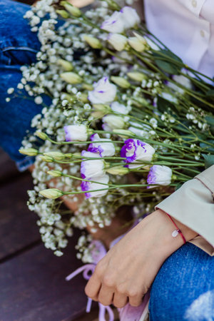 a bouquet of flowers in the hands of a girl. bouquet with small flowersの写真素材