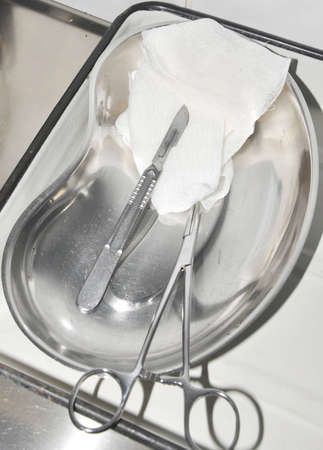 the scalpel and clip lie in a trayの写真素材