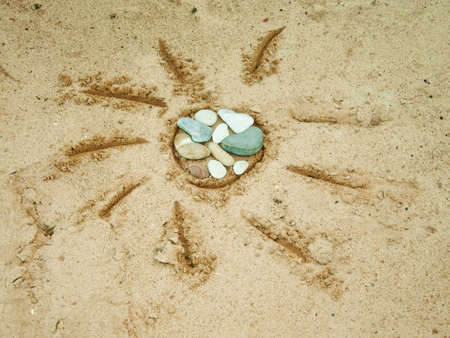 The sun is drawn on wet sand