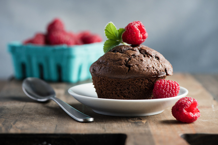 Chocolate muffins or cupcakes with raspberries, healthy breakfast, homemade snack, selective focus, toned image.の写真素材