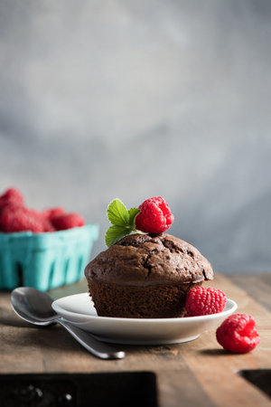Chocolate muffins or cupcakes with raspberries, healthy breakfast, homemade snack, selective focus, toned image.の写真素材