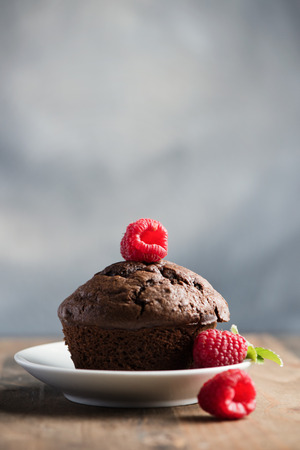 Chocolate muffins or cupcakes with raspberries, healthy breakfast, homemade snack, selective focus, toned image.の写真素材