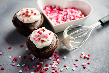 Chocolate muffins or cupcakes with heart sprinkles. St. Valentines day baking. Selective focus, toned image.の写真素材