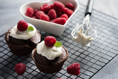 Chocolate muffins or cupcakes with raspberries, healthy breakfast, homemade snack, selective focus, toned image.の写真素材