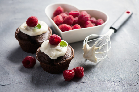 Chocolate muffins or cupcakes with raspberries, healthy breakfast, homemade snack, selective focus, toned image.の写真素材