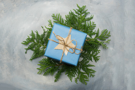 Christmas gift box in blue wrapping paper. Copy space. Toned image, falling snow effect.の写真素材