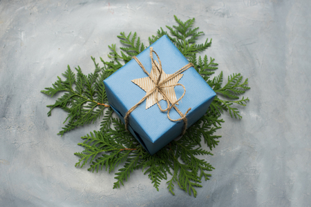 Christmas gift box in blue wrapping paper. Copy space. Toned image, falling snow effect.の写真素材