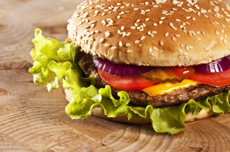 Cheeseburger with onions tomato and ketchupの写真素材