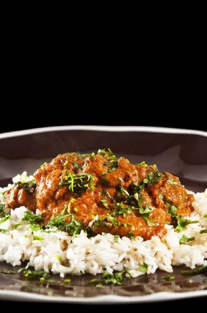 Chicken tikka masala served  with rice and garnished with cilantro leavesの写真素材