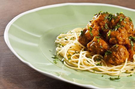 Spaghetti and meat balls with tomato sauce garnished with basilの写真素材