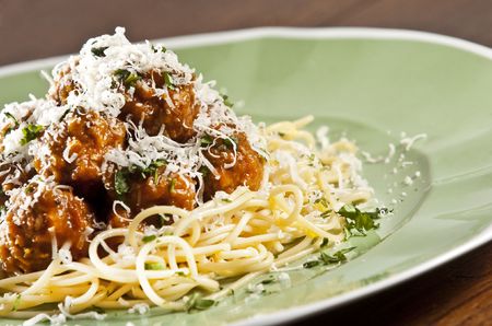 Spaghetti and meat balls with tomato sauce garnished with basilの写真素材