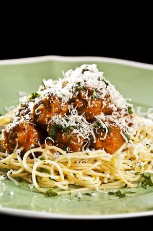 Spaghetti and meat balls with tomato sauce garnished with basilの写真素材