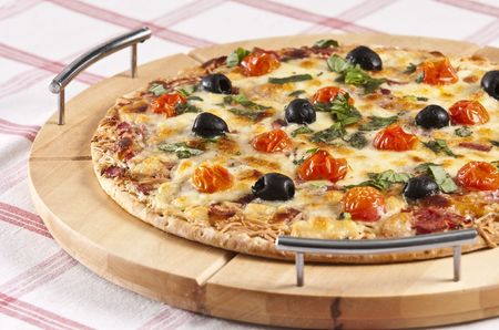 baked pizza served on wooden boardの写真素材
