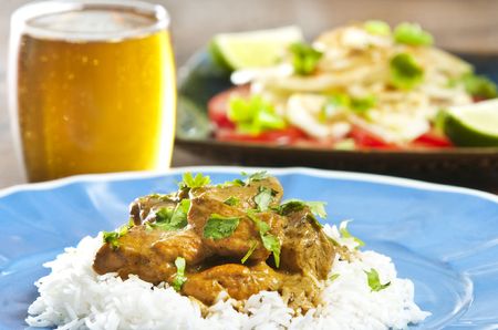 Chicken curry served  with rice and garnished with cilantro leavesの写真素材