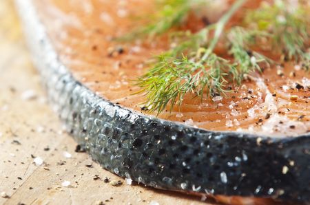 Raw salmon fillet on an old wooden kitchen boardの写真素材