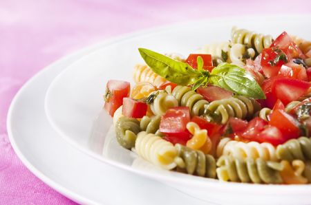 Pasta primavera garnished with basil leavesの写真素材
