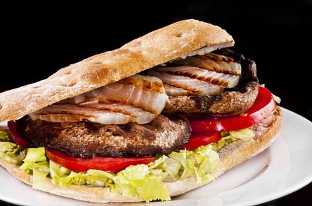 Portobello sandwich with grilled onion lettuce and tomatoの写真素材