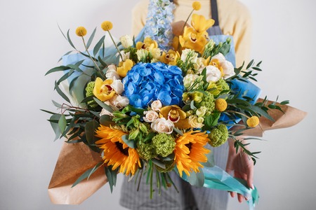 Rich bunch of pink eustoma and roses flowers, green leaf in hand Fresh spring bouquet. Summer Backgroundの写真素材