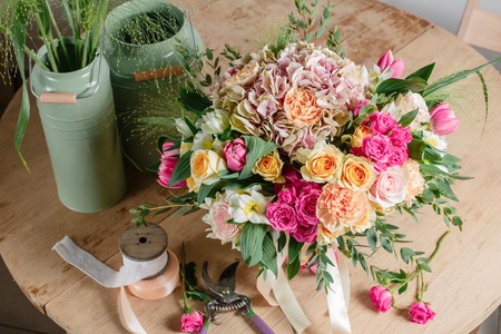 Vintage floristic background, colorful roses, antique scissors and a rope on an wooden tableの写真素材