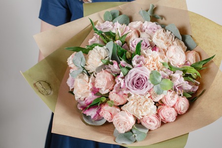 Florist girl with rich bunch flowers. Fresh spring bouquet. Summer Background. Young woman with flower bouquet for birthday or mother's day.の写真素材