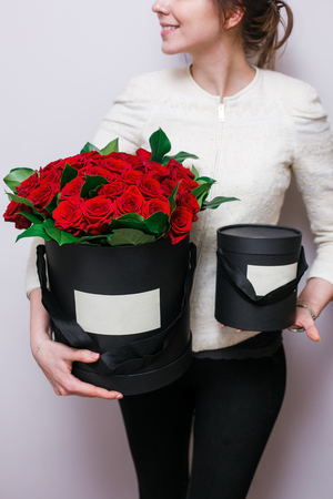 Luxury bouquets of flowers in the hat box. roses in the hands of women.の写真素材