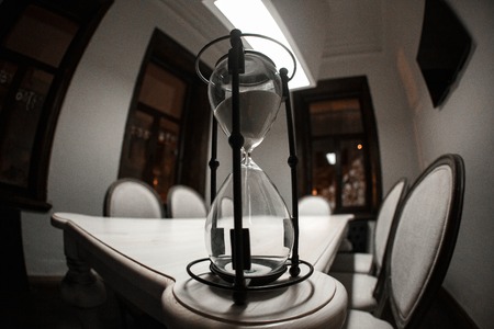 Beautiful hourglass on brown wood table with shadow.の写真素材