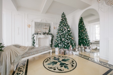 Christmas morning. classic apartments with a white fireplace, decorated Christmas tree, bright sofa, large windows.の写真素材