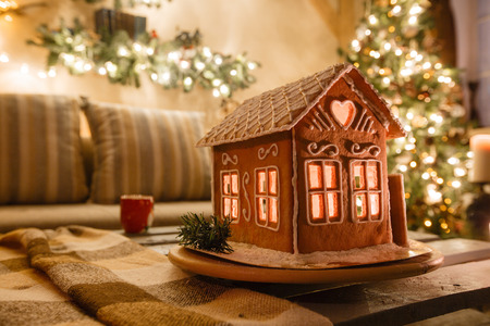 Homemade gingerbread house on background room decorated for Christmasの写真素材