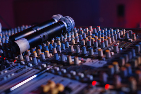Soundman working on the mixing console in concert hall