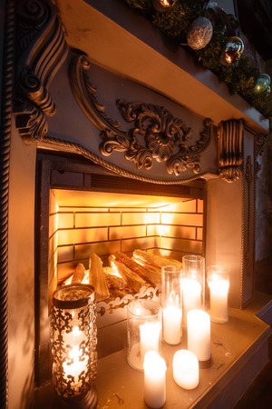 Christmas Eve. fireplace in the room with candles. spruce decorated with balloons.の写真素材