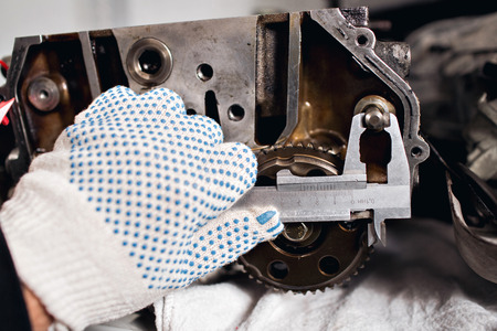 mechanical technician worker hands measuring detail tool after processing at workshop with sliding caliper at manufacturingの写真素材