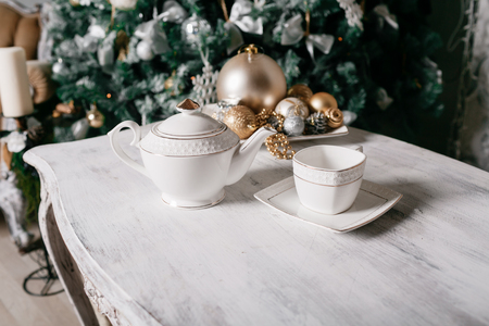Christmas decorations on the table against the background of a fireplace decorated with branches of spruce and garlandの写真素材