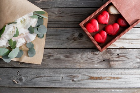 Red macaroons desserts and buttercups on wooden background. dessert for breakfast on Valentines Day. copy spaceの写真素材