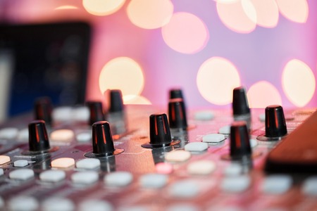 od adjusters and red buttons of a mixing console. It is used for audio signals modifications to achieve the desired output. Applied in recording studios, broadcasting, television.の写真素材