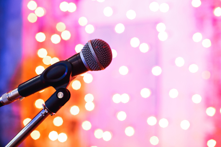 Close up of microphone in concert hall with blurred lights at backgroundの写真素材