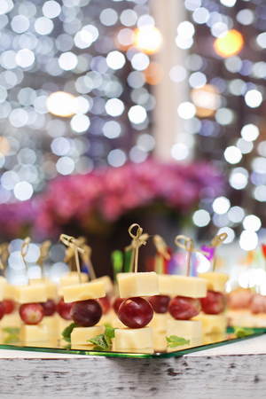 Appetizer of grape, pineapple cubes and cheese are on wooden skewers.の写真素材