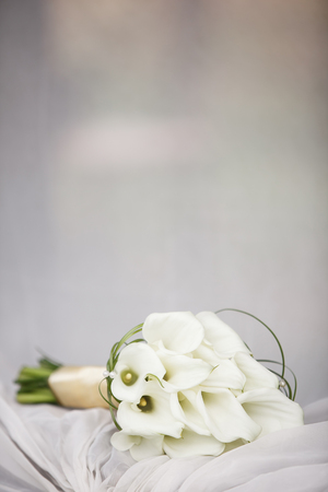 Elegant bridal bouquet of white calla lilies, boutonniere on the tableの写真素材
