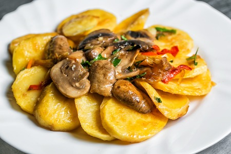 Fried potato with mushrooms and herbs. white plate. selective focusの写真素材
