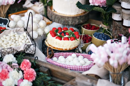 Dessert table for a party. Ombre cake, cupcakes, sweetness and flowersの写真素材