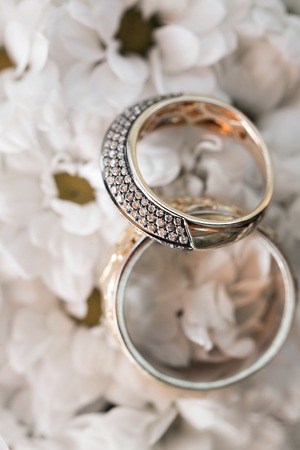 Wedding rings on a white flowers pillow. accessories wedding closeup. selective focus