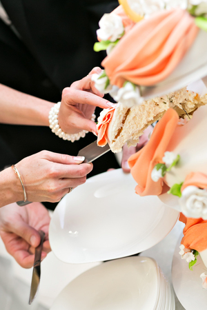 the couple cut the cake. the bride takes a piece. Image of a beautiful wedding cake at wedding receptionの写真素材