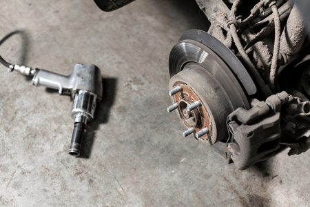 Closeup disc brake of the vehicle for repair. shot wheel, the tool for loosening the nuts. internal screwの写真素材