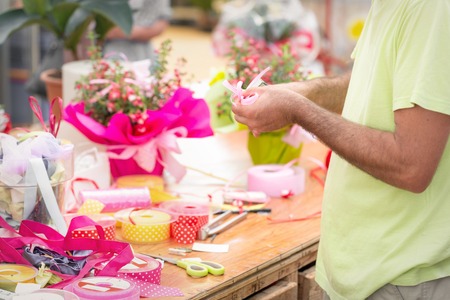 closeup florist making a ribbon bow. Shallow depth of field, focus on handの写真素材