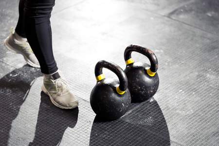 Kettlebell on floor. Girl training in gymの写真素材