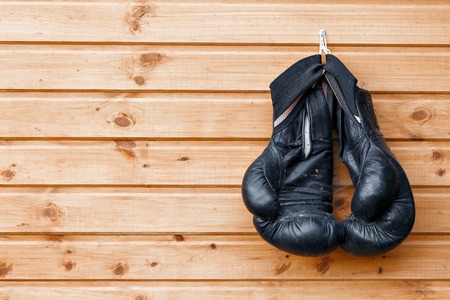 Pair of boxing gloves hanging in a rustic wooden wall.の写真素材
